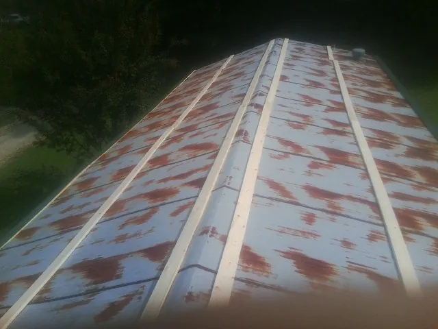 Rusted metal roof panels with new wood purlins before replacement — Storm Damage Roof Repair in Newfoundland by Roofing Brothers